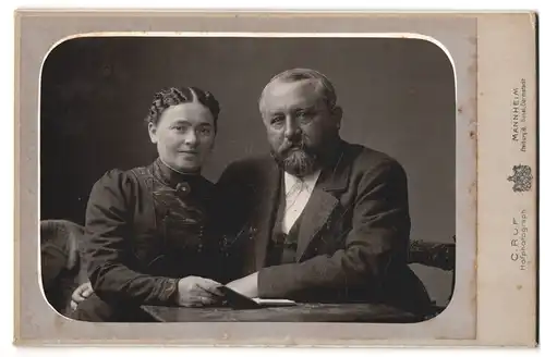 Fotografie C. Ruf, Mannheim, Portrait älteres Paar in modischer Kleidung mit Buch