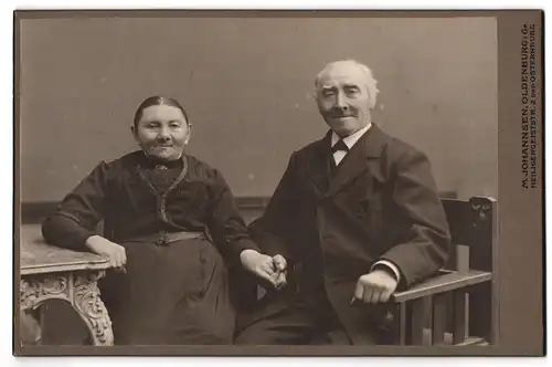 Fotografie M. Johannsen, Oldenburg i. Gr., Heiligengeiststrasse 2, Portrait älteres Paar in hübscher Kleidung