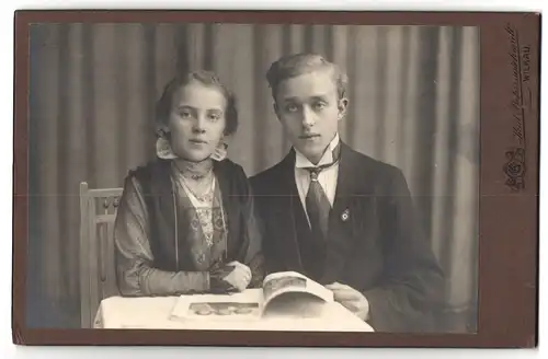 Fotografie Kurz Behringschmidt, Wilkau i /S., Portrait junger Herr mit Mädchen in modischer Kleidung mit Zeitung