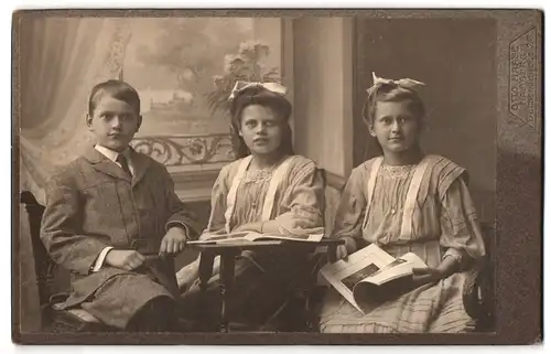 Fotografie Otto Haase, Hamburg, Börsenbrücke 2a, zwei Schülerinnen und ein Knabe bei der Lektüre von Bildbänden