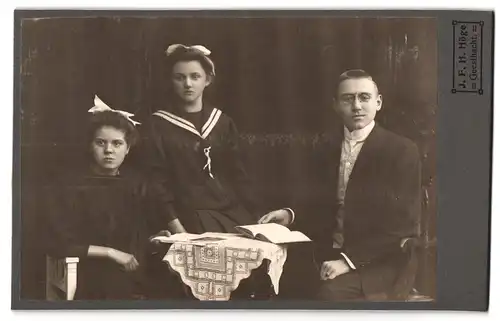 Fotografie J. F. H. Höge, Geesthacht, junger Herr mit Zwicker und Mädchen in schwarzen Kleidern