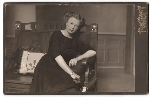 Fotografie Carl Boelte, Einbeck i. H., Markt 12 /14, junge Dame in schwarzem Kleid auf einer Sitzbank