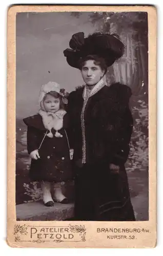 Fotografie Atelier Petzold, Brandenburg a. H., Kurstr. 52, Portrait Mutter im Pelzkleid mit Tochter im WInterkleid, Hut