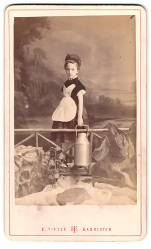 Fotografie E. Tietze, Bad Elster, Portrait Mädchen als Bäderfrau mit Kanne voll Quellwasser aus der Marienquelle