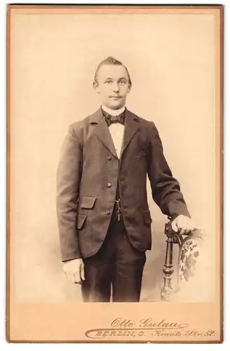 Fotografie Otto Gutau, Berlin-O, Krauts-Strasse 52, Portrait junger Herr im Anzug mit Fliege