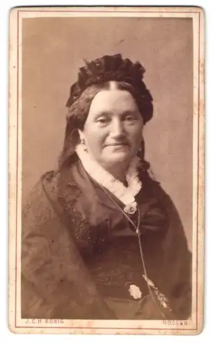 Fotografie J.Ch. König, Nossen, Bahnhofstrasse, Portrait lächelnde Dame mit schönem Kopfputz