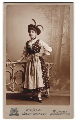 Fotografie Atelier Oberpollinger, München, Neuhauser-Str. 44-46, Portrait Dame im Trachtenkleid mit Federhut vor Kulisse