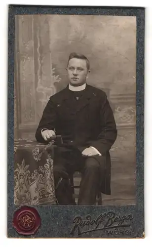 Fotografie Rudolf Berger, Wörgl, Portrait Pfarrer im Talar mit Collar und Bibel in der Hand