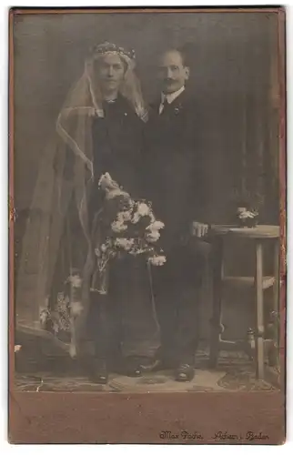 Fotografie Max Pache, Achern i. Baden, Portrait Eheleute im schwarzen Hochzeitskleid und Anzug mit Zylinder