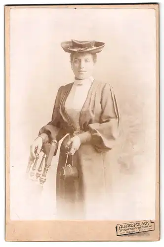 Fotografie Alfred Polack, Schöneberg, Hauotstr. 11, Portrait Dame im dunklen Kleid mit Handtasche und Hut