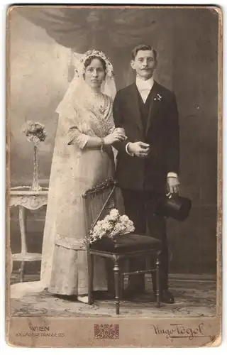 Fotografie Hugo Tögel, Wien, Jägerstr. 25, Portrait junges Ehepaar im Hochzeitskleid und Anzug mit Zylinder