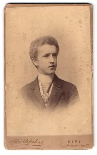 Fotografie Ferd. Urbahns, Kiel, Schlossgarten 17, Portrait junger Mann im Anzug mit Krawatte