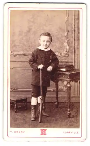 Fotografie T. Henry, Lunéville, Portrait modisch gekleideter Junge mit Gewehr