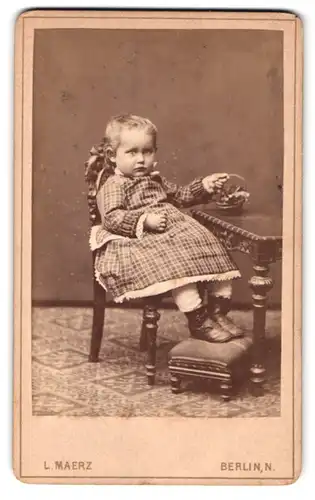 Fotografie L. Maerz, Berlin, Badstr. 62, Portrait kleines Mädchen im karierten Kleid an einem Kindertisch samt Stuhl