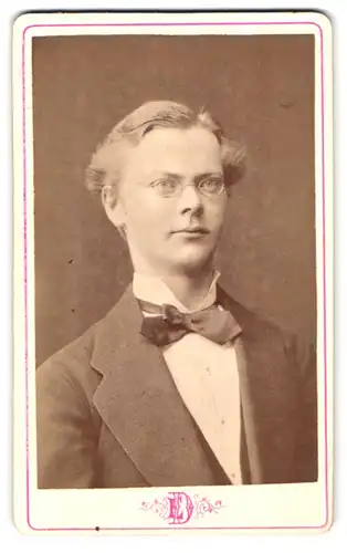 Fotografie E. Dahlberg, Eskilstuna, Portrait junger Schwede im Anzug mit Fliege und Brille