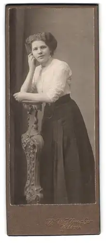 Fotografie Walbrecker, Zittau, Theodor Körner Allee, Portrait Dame in weisser Bluse und schwarzem Rock auf Säule gestützt