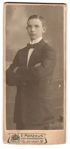 Fotografie E. Motzkus, Halle a. S., Ulrichstr. 57, Portrait junger Knabe im Anzug mit Fliege und verschrenkten Armen