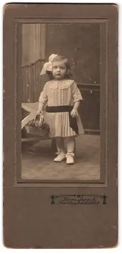 Fotografie Herm. Jursch, Nürnberg, Tafelfeldstrasse 8, Portrait kleines Mädchen im Kleid mit Blumenkorb