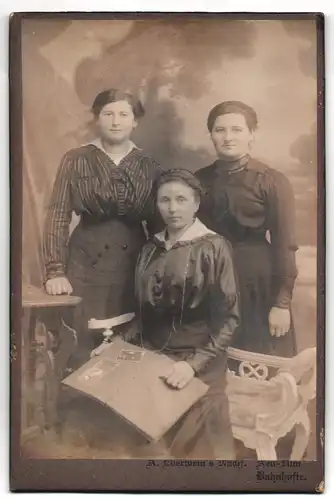 Fotografie A. Eberwein`s Nachf., Neu-Ulm, Bahnhofstrasse, Portrait drei modisch gekleidete Damen mit Fotoalbum