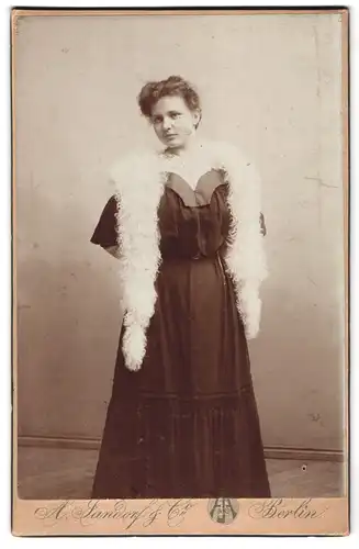 Fotografie A. Jandorf, Berlin, Kottbuserdamm 1-2, junge Frau in schwarzem Kleid mit Federboa