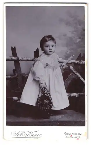 Fotografie Wilh. Knarr, Rosenheim, Innstrasse 42, Portrait kleines Mädchen im Kleid mit Ball