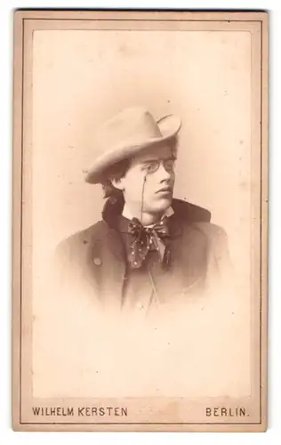 Fotografie Wilhelm Kersten, Berlin-SW, Krausen-Strasse 40, Portrait junger Herr im Mantel mit Hut und Zwicker