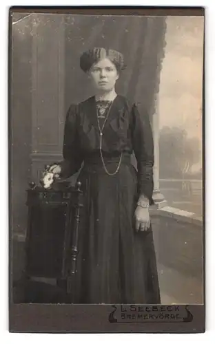 Fotografie L. Seebeck, Bremervörde, Portrait junge Dame im Kleid mit Blume