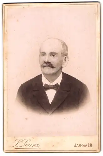 Fotografie L. Lorenz, Jaromer, Portrait Herr im Anzug mit Fliege und Walrossbart, Halbglatze