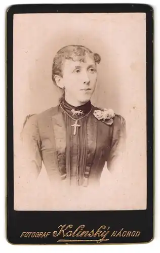 Fotografie Kolinsky, Nachod, Portrait Dame im taillierten Kleid mit Kreuzkette und Ansteckblume