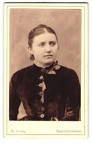 Fotografie Fr. Seelig, Neuhaldensleben, Langestr. 50, Portrait bildschönes Fräulein mit Brosche und Schleife am Kragen