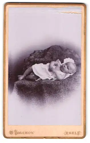 Fotografie W. Dalchow, Egeln, Breiteweg 76, Portrait süsses Baby auf einer bestickten Decke liegend
