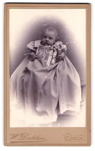 Fotografie W. Dalchow, Egeln, Breiteweg 76, Portrait niedliches Baby im eleganten Taufkleidchen