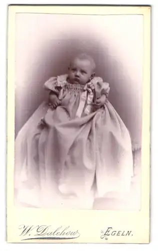 Fotografie W. Dalchow, Egeln, Breiteweg 76, Portrait niedliches Baby im Taufkleidchen