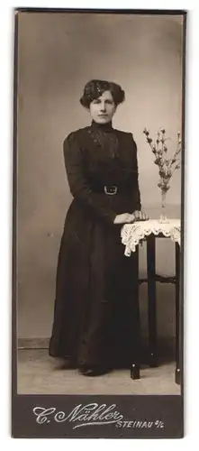 Fotografie C. Nähler, Steinau, Portrait dunkelhaarige junge Frau elegant am Tisch stehend