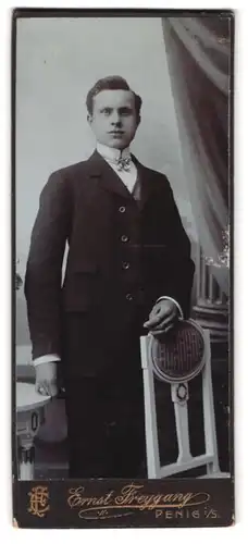 Fotografie Ernst Freygang, Penig i. S., Portrait charmanter junger Mann steht elegant an einem Stuhl