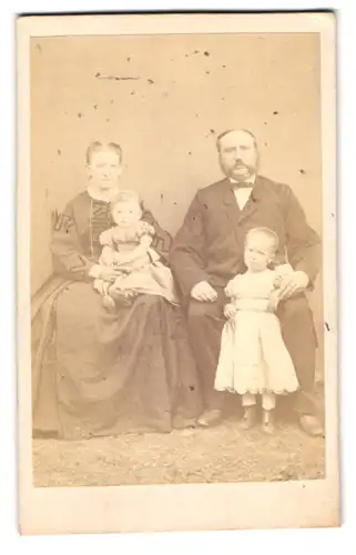 Fotografie unbekannter Fotograf und Ort, Portrait einer elegant gekleideten Familie mit zwei hübschen Töchtern