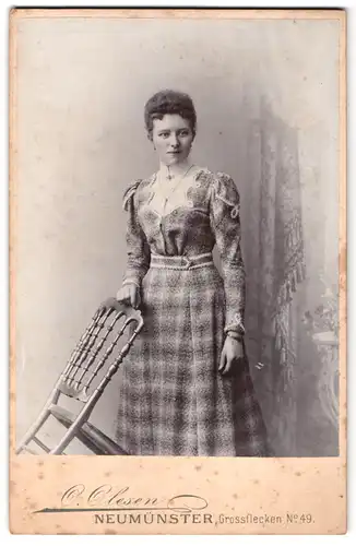Fotografie O. Olesen, Neumünster, Grossflecken 49, junge Frau in kariertem Kleid mit freundlichen Lächeln