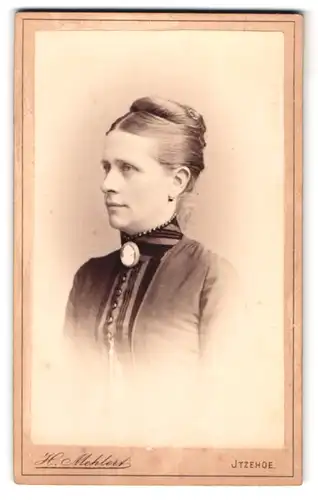 Fotografie H. Mehlert, Itzehoe, Breitestrasse 14, Portrait junge Dame mit Hochsteckfrisur und Kragenbrosche