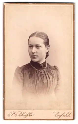 Fotografie P. Schiffer, Crefeld, Neue Linnerstrasse 74, Portrait junge Dame im Kleid mit Halskette