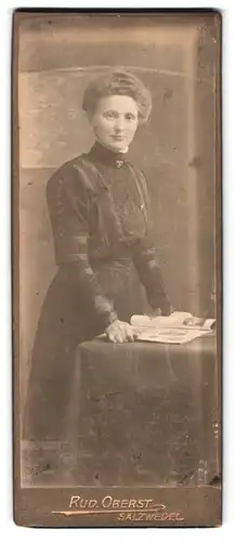 Fotografie Rud. Oberst, Salzwedel, Breitestrasse 8, Portrait junge Dame im Kleid mit Zeitung