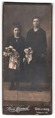 Fotografie Hans Heinrich, Oranienburg, Portrait zwei schwarz gekleidete Mädchen mit Blumensträussen