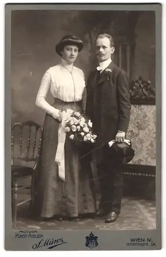 Fotografie F. Münz, Wien, Favoritenstrasse 58, Portrait junges Paar in hübscher Kleidung mit Blumenstrauss