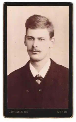 Fotografie L. Bresslmair, Meran, Portrait modisch gekleideter Herr mit Oberlippenbart