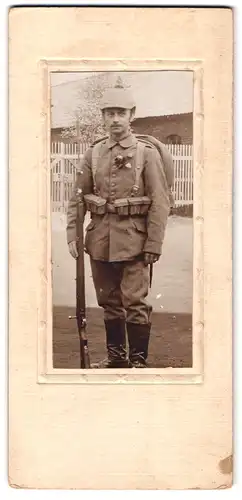 Fotografie unbekannter Fotograf und Ort, Soldat in Ausmarschuniform mit Pickelhaube Überzug und Bajonett 1915