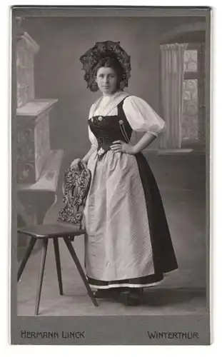 Fotografie Hermann Lick, Winterthur, St. Georgenstr. 38, Portrait junge Frau in Tracht vor einer Studiokulisse