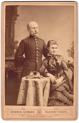 Fotografie Heinrich Axtmann, Plauen i. V., Portrait Bahnbeamter in Uniform mit Walrossbart nebst seiner Frau