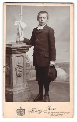 Fotografie Franz Ress, Freising, Portrait junger Knabe im Anzug mit Kerze, Kommunion