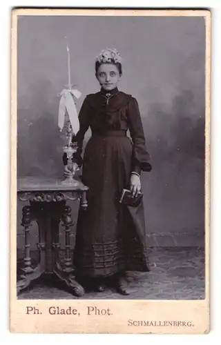 Fotografie Ph. Glade, Schmallenberg, Portrait Mädchen im dunklen Kleid mit Kommunionskerze und Bibel