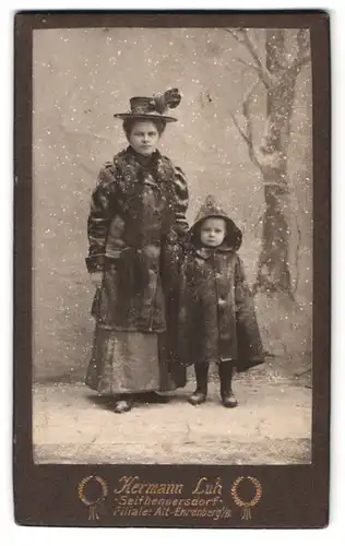 Fotografie Hermann Luh, Seifhennersdorf, Portrait Mutter mit Kind in Winterkleidung in einer Winterlandschafts Kulisse