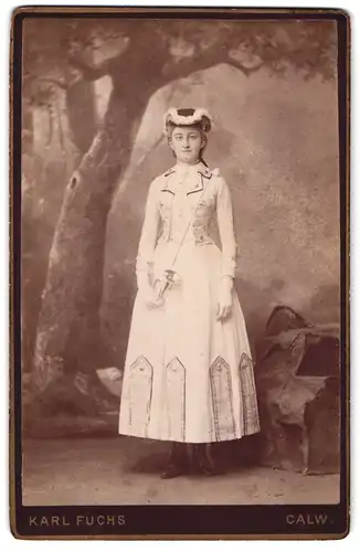Fotografie Karl Fuchs, Calw, Portrait junge Frau im Bühnenkostüm mit Jagdhorn vor einer Studiokulisse